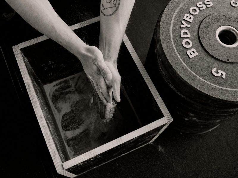 Close up of gym equipment and a woman's hands preparing for a workout.